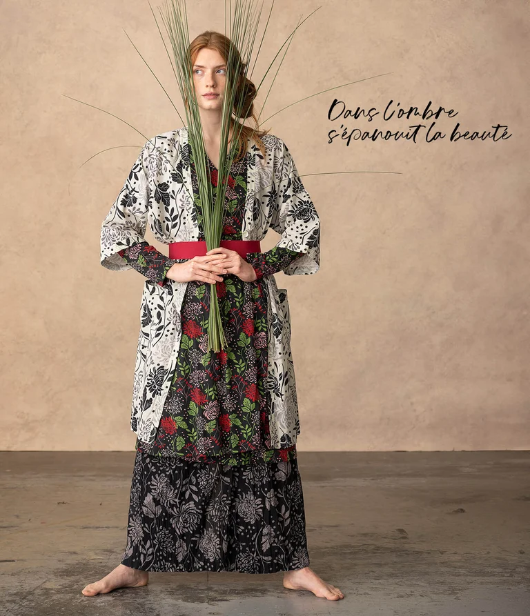 A woman wearing layers of patterned clothing from Gudrun Sjödén. 