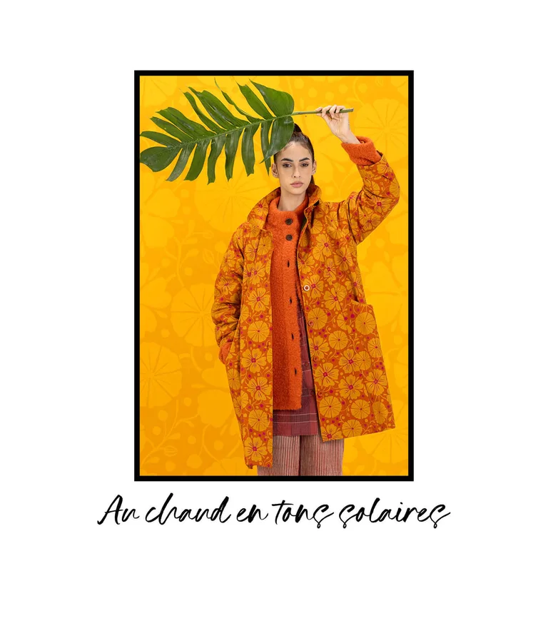 A woman wearing a patterned orange coat from Gudrun Sjödén.