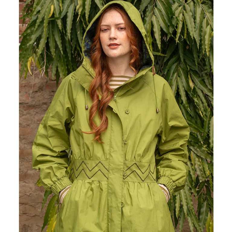 A woman wearing a green parka from Gudrun Sjödén with the hood up. 