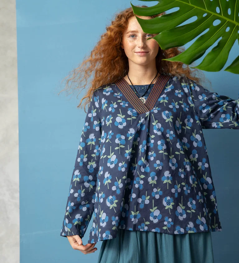 A woman wearing a floral blouse from Gudrun Sjödén.