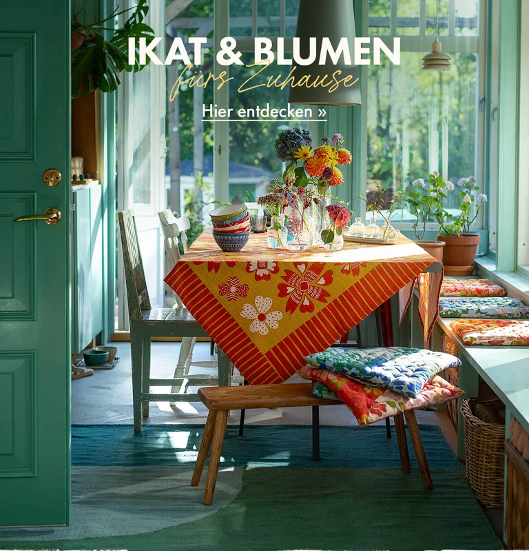 Eine Tischdekoration mit farbstarken Heimtextilien von Gudrun Sjödén.