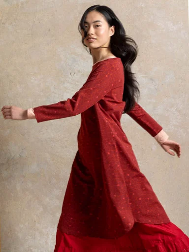 A woman wearing a red jersey dress from Gudrun Sjödén.