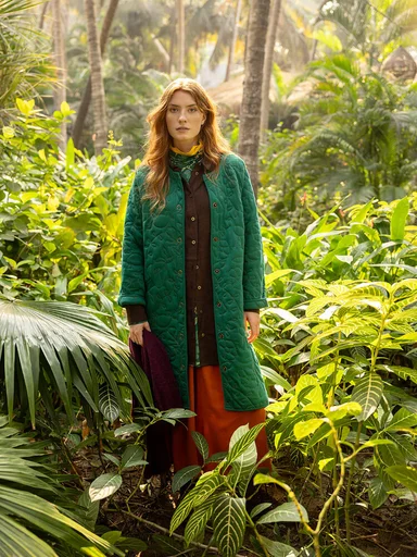 A woman wearing a green jacket from Gudrun Sjödén. 