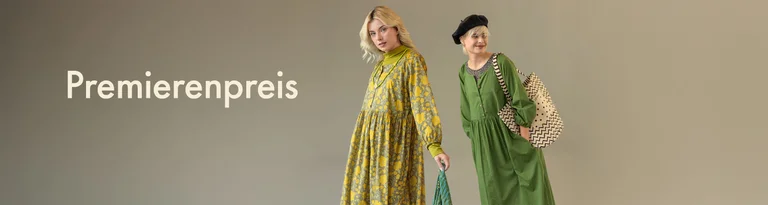 Zwei Frauen in Kleidung von Gudrun Sjödén stehen vor einem neutralen Hintergrund, mit dem Text 'Premierenpreis' links.