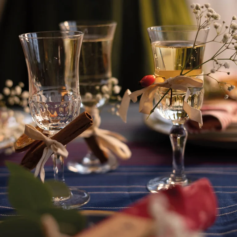Feestelijk gedekte tafel met woontextiel van Gudrun Sjödén, vintage servies en groene decoraties.