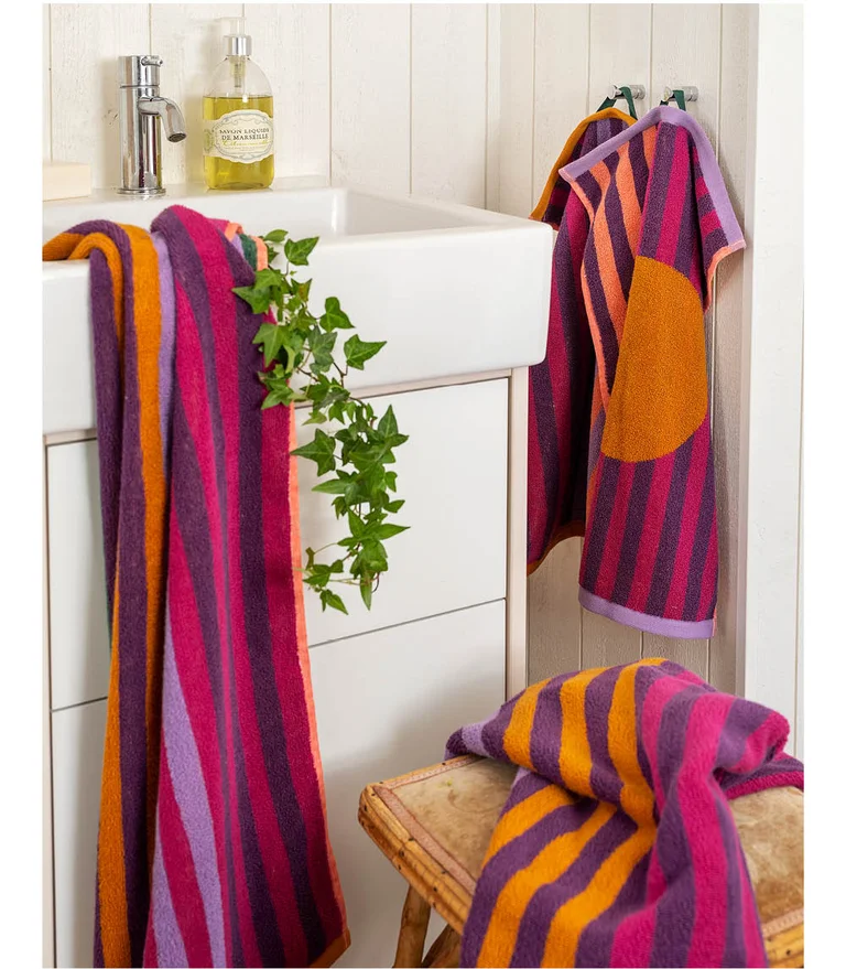 Une salle de bain décorée de serviettes-éponges colorées.