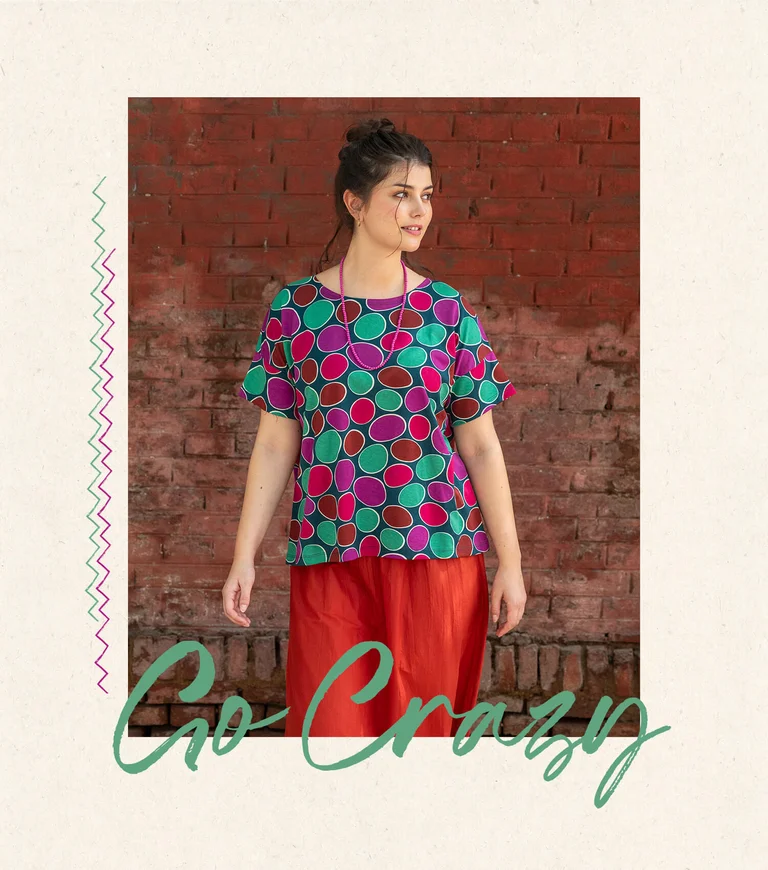A woman wearing a dotted top and red skirt from Gudrun Sjödén.