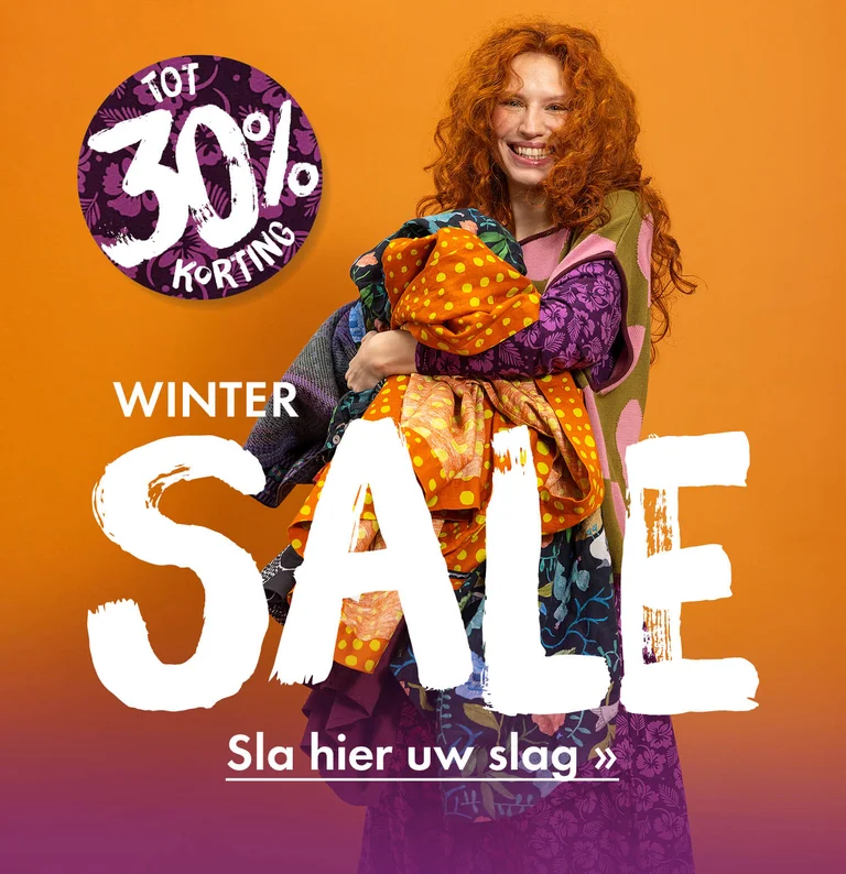 Een vrouw met kleurrijke kleding van Gudrun Sjödén in haar armen.