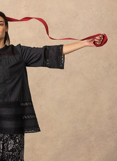 A woman wearing a black blouse from Gudrun Sjödén.
