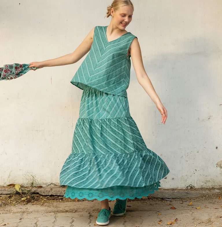 A woman wearing a turquoise tank top and turquoise skirt from Gudrun Sjödén.