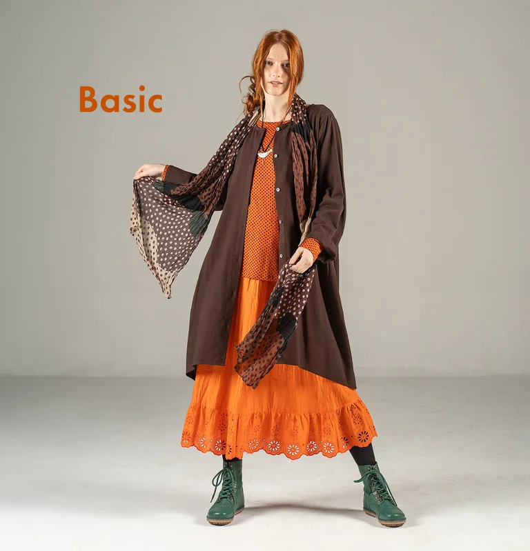 Eine Frau im Lagenlook in Braun-Orange von Gudrun Sjödén.  