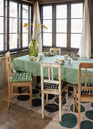 Une table avec des textiles d'intérieur signés Gudrun Sjödén.