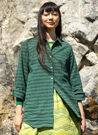 A woman wearing a green shirt from Gudrun Sjödén.