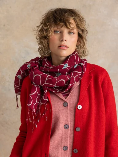 A woman wearing red and pink knitwear from Gudrun Sjödén. 