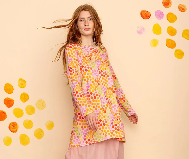 A woman wearing a colourful, dotted tunic from Gudrun Sjödén.