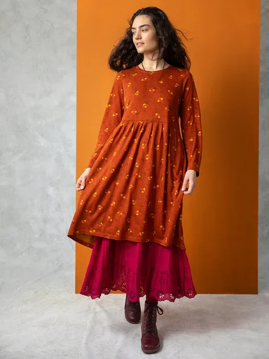 A woman wearing an orange dress from Gudrun Sjödén.
