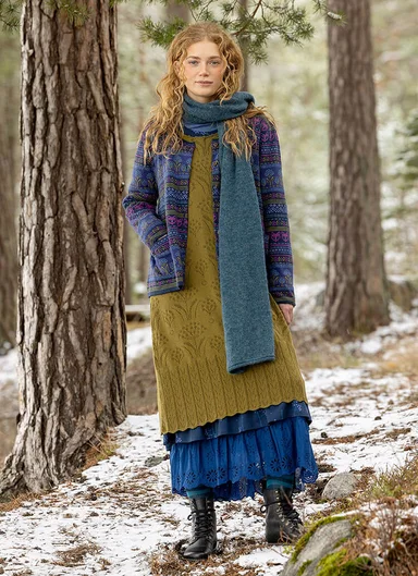 A woman standing in the forest wearing clothes from Gudrun Sjödén. 