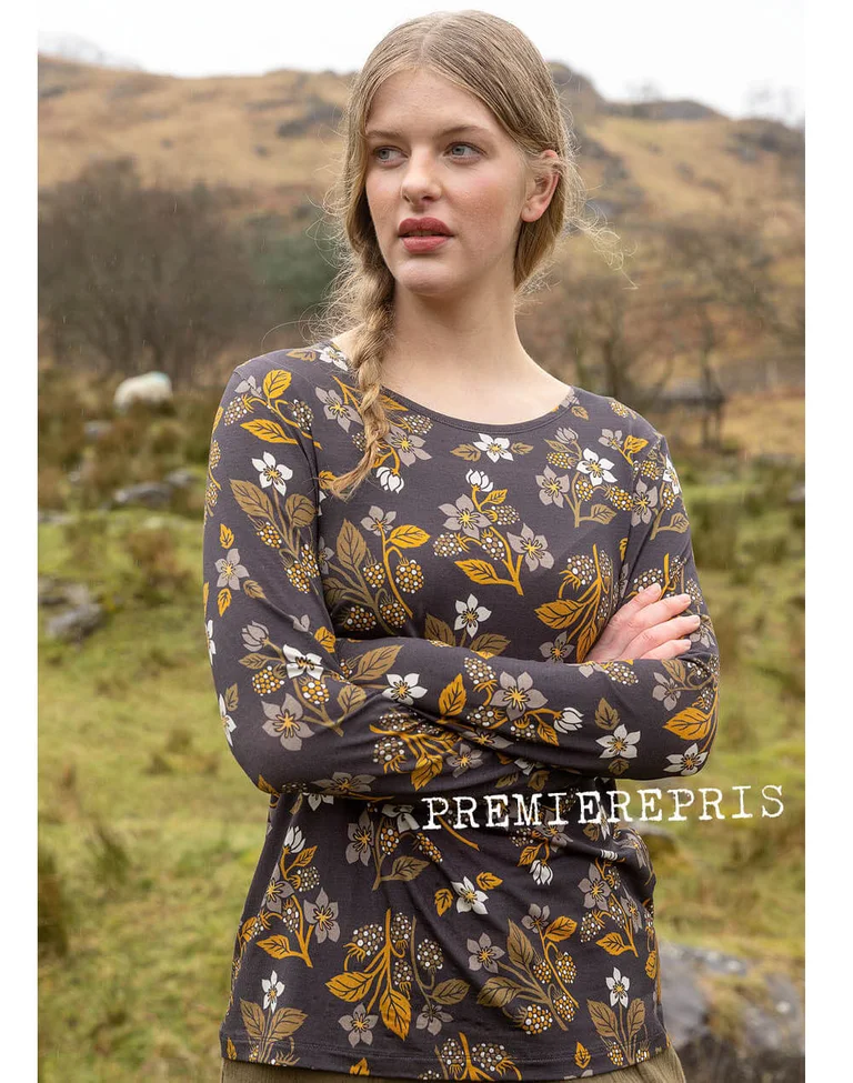 A woman wearing a patterned top from Gudrun Sjödén.
