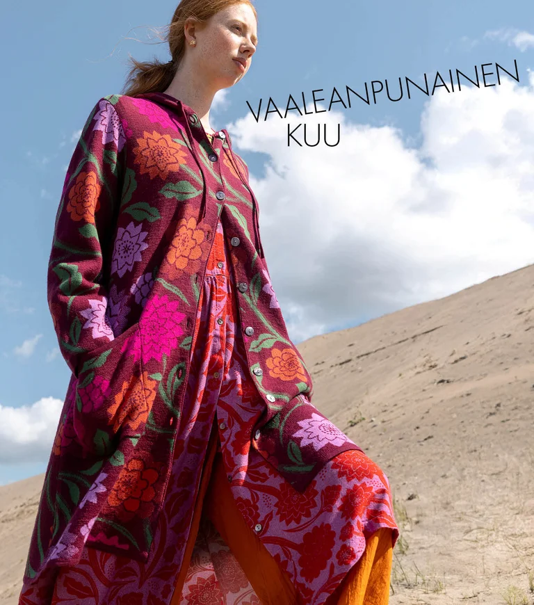 A woman wearing a floral dress and cardigan from Gudrun Sjödén. 