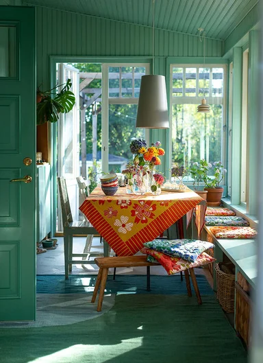 A table laid with colourful textiles from Gudrun Sjödén.