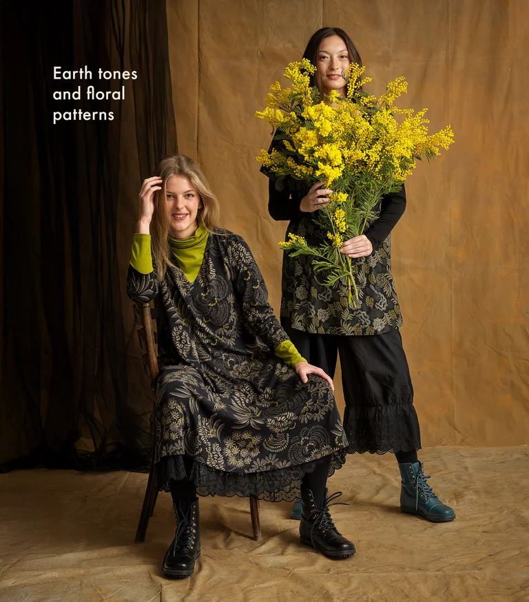 Two women next to each other wearing layers of clothing in shades of black and gray from Gudrun Sjödén.