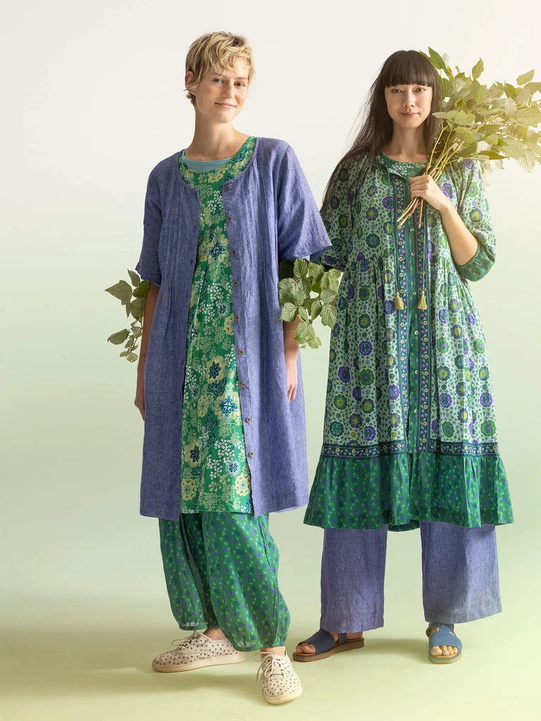 A woman wearing a patterned green dress from Gudrun Sjödén.