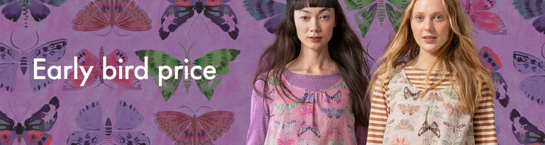 Two women wearing butterfly-patterned clothing stand against a matching purple background.