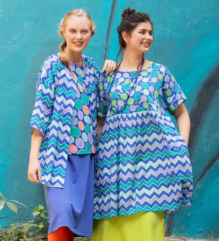 Two women wearing patterned blue clothing from Gudrun Sjödén.