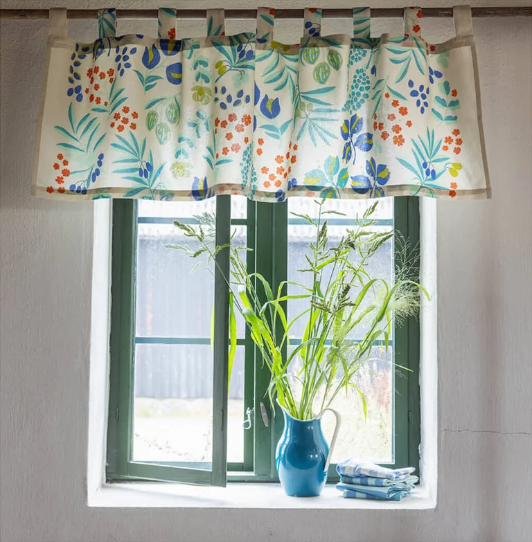 A window with a patterned valance from Gudrun Sjödén.
