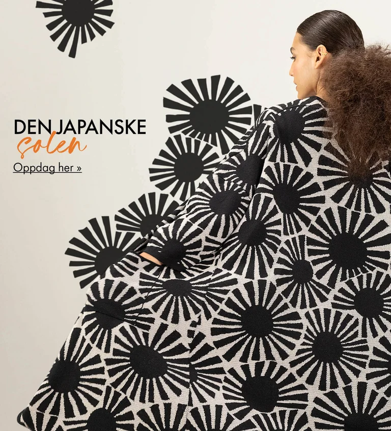 En kvinne med ryggen mot kamera som har på seg en lang strikkejakke med et svart, grafisk solmønster fra Gudrun Sjödén. Mønsteret er forlenget ut i bildet, slik at det ser ut som det flyter ut fra strikkejakken.