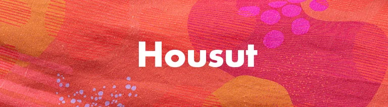 Kukallinen kuvio, jossa valkoinen teksti ”Housut”.