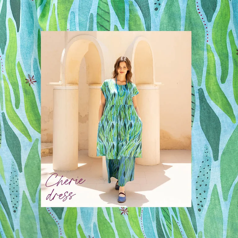 A woman wearing green, patterned clothes from Gudrun Sjödén’s Paris collection. There is a frame with the same pattern as on the clothes around the picture. 