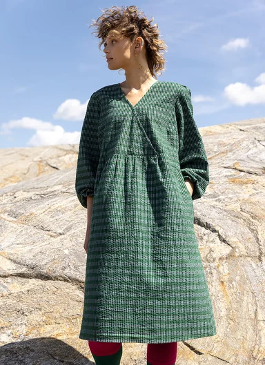 A woman wearing a green dress from Gudrun Sjödén.