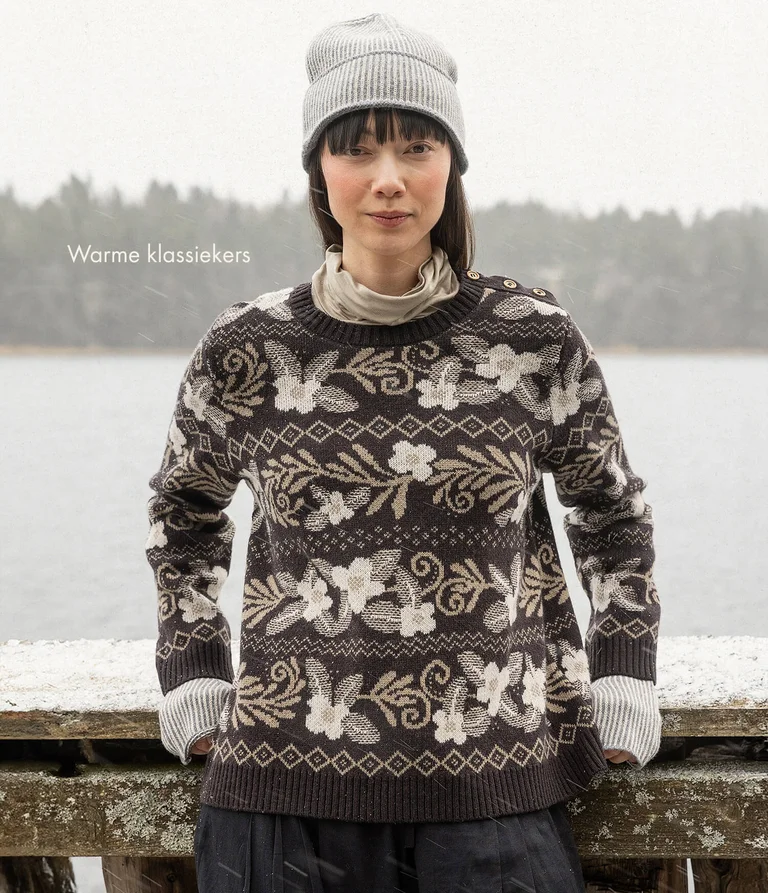 A woman wearing a floral knit sweater from Gudrun Sjödén. 