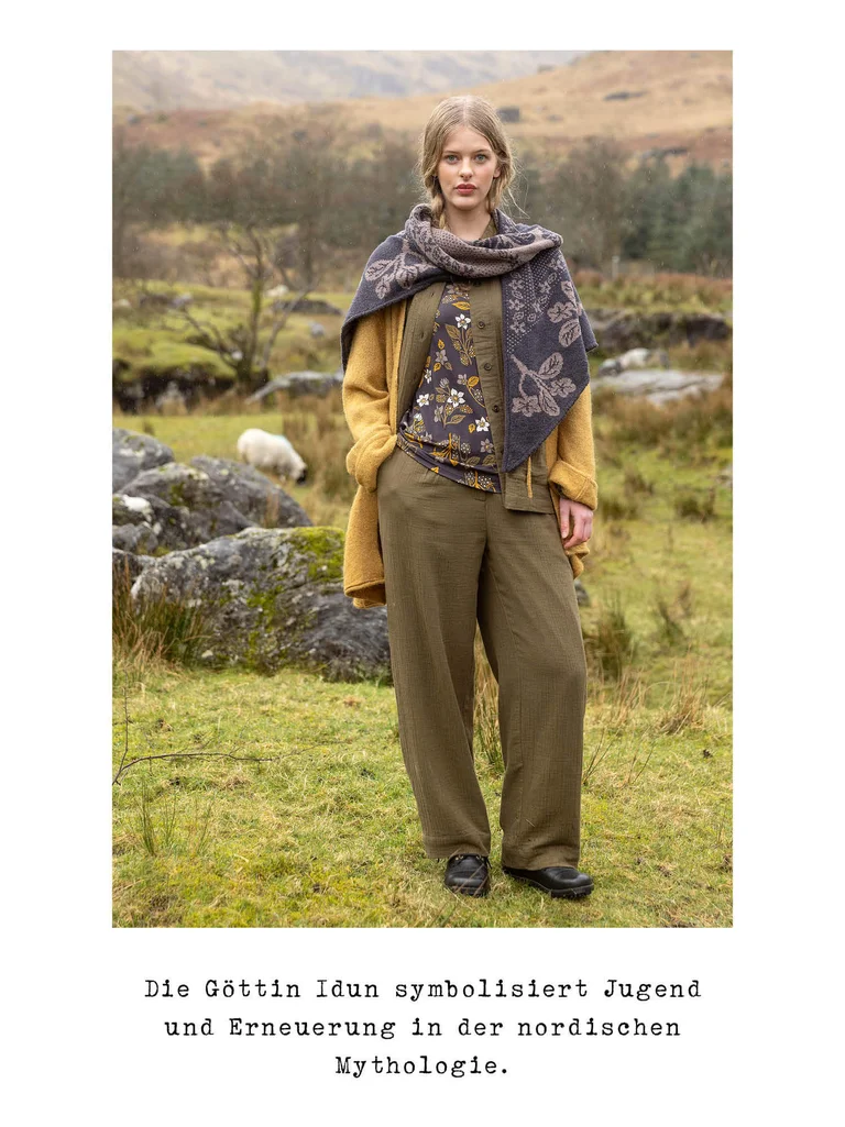 A woman posing outdoors wearing layers of clothing from Gudrun Sjödén.