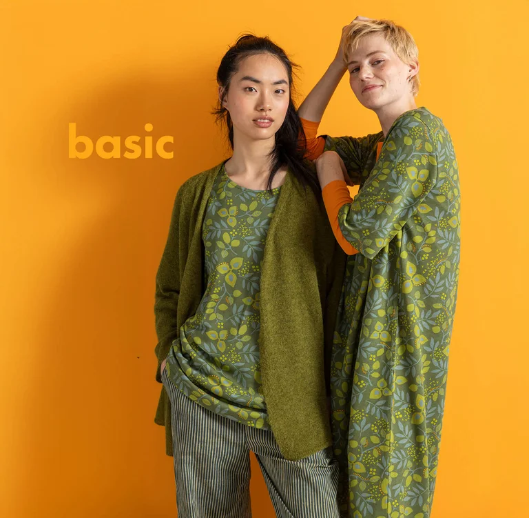 Two women wearing layers of green clothes from Gudrun Sjödén’s essentials collection.