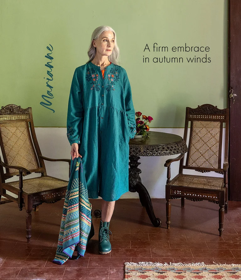 A woman wearing a blue embroidered dress from Gudrun Sjödén. 