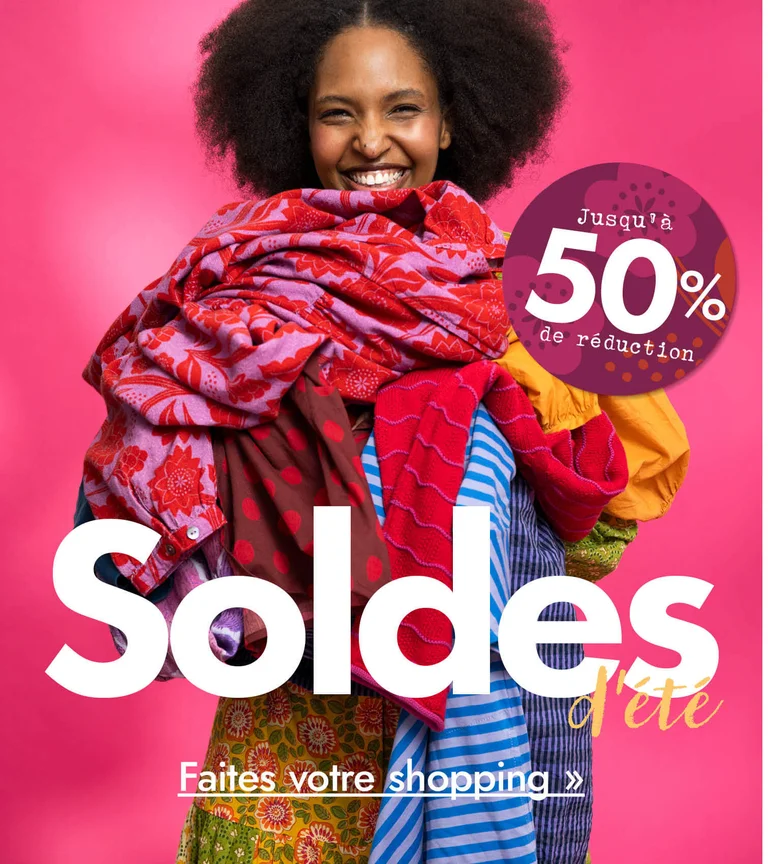 A woman with her arms full of colourful clothes from Gudrun Sjödén.