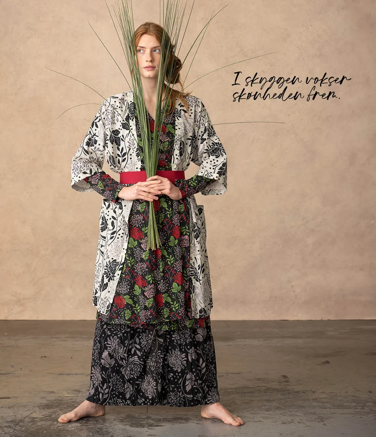 A woman wearing layers of patterned clothing from Gudrun Sjödén. 