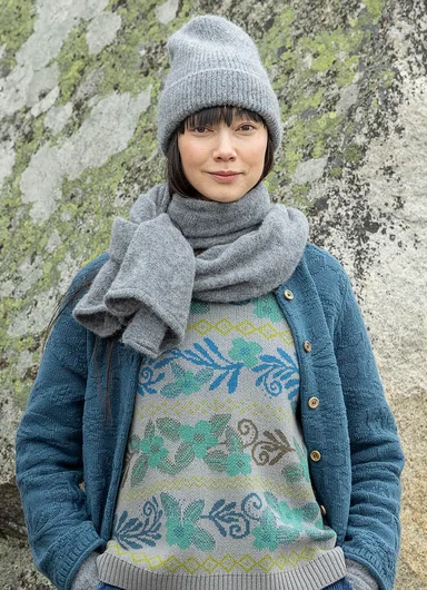 Une femme portant une écharpe en maille et un bonnet signés Gudrun Sjödén.