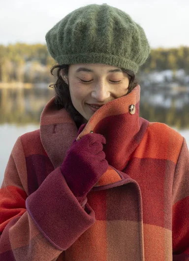 A woman wearing a knitted scarf and beanie from Gudrun Sjödén.