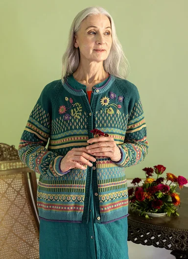  A woman wearing a patterned knitted cardigan from Gudrun Sjödén.