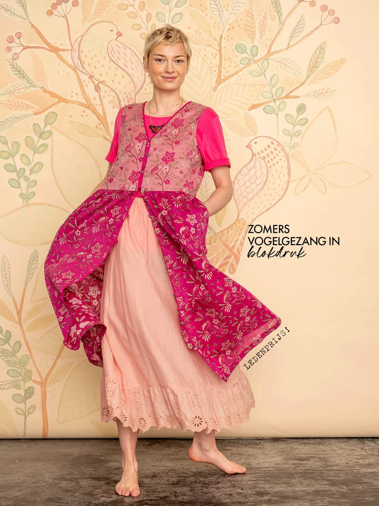 A woman wearing a pink floral dress from Gudrun Sjödén.
