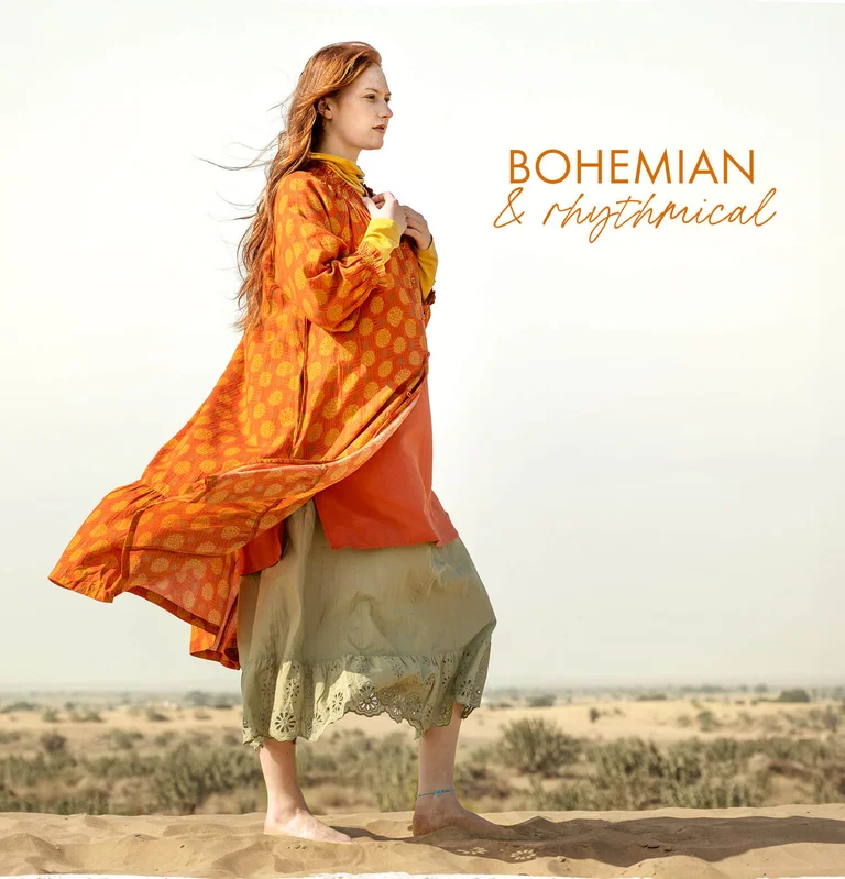 A woman wearing layers of colourful cotton clothes from Gudrun Sjödén. 