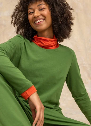 A woman wearing green jersey clothes from Gudrun Sjödén.