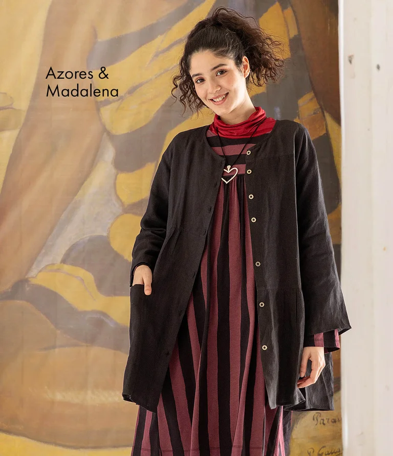 A woman wearing an artist’s blouse in black and a striped dress from Gudrun Sjödén. 