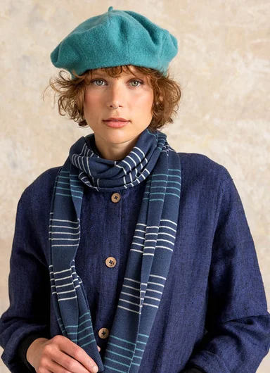 A woman holding a bunch of patterned and colourful scarves from Gudrun Sjödén in each hand.