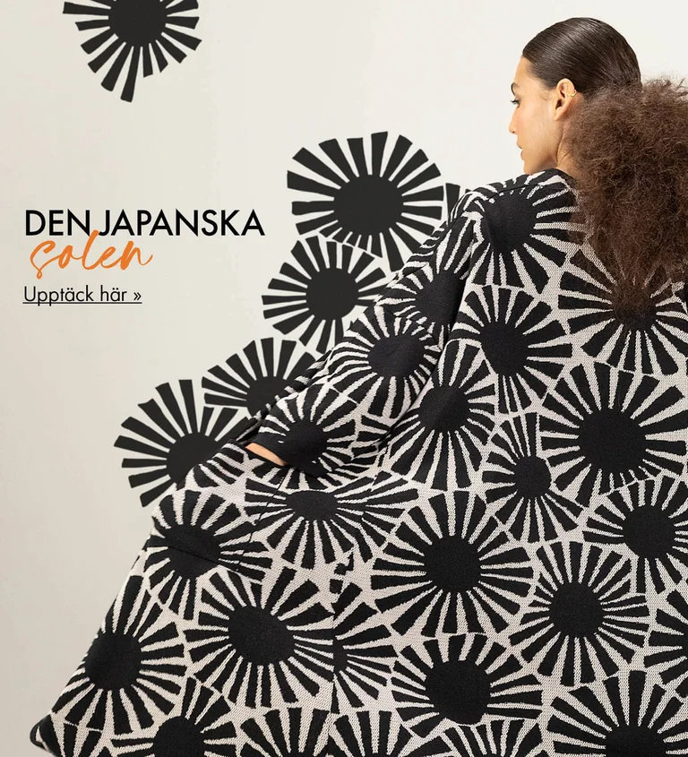 En kvinna med ryggen mot kameran, som bär en lång kofta mönstrad med svarta, grafiska solar från Gudrun Sjödén. Mönstret har förlängts ut i bilden, så att det ser ut att flyta ut från koftan.