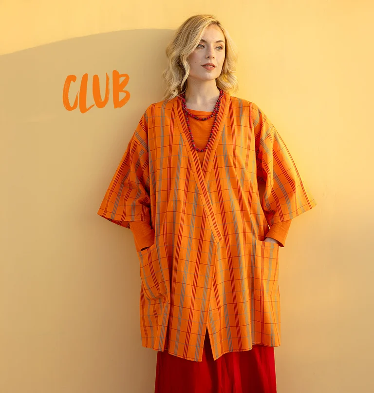 En kvinde iført en ternet, orange kimono fra Gudrun Sjödén.