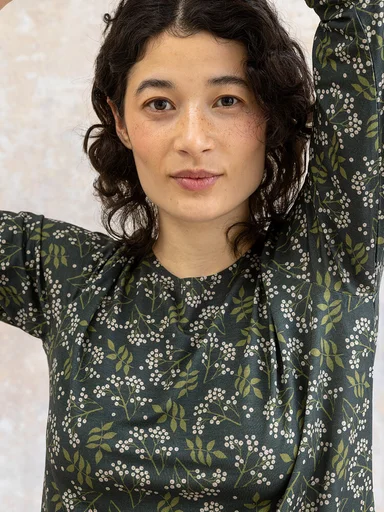 Eine Frau in einem gemusterten Jerseyshirt von Gudrun Sjödén. 